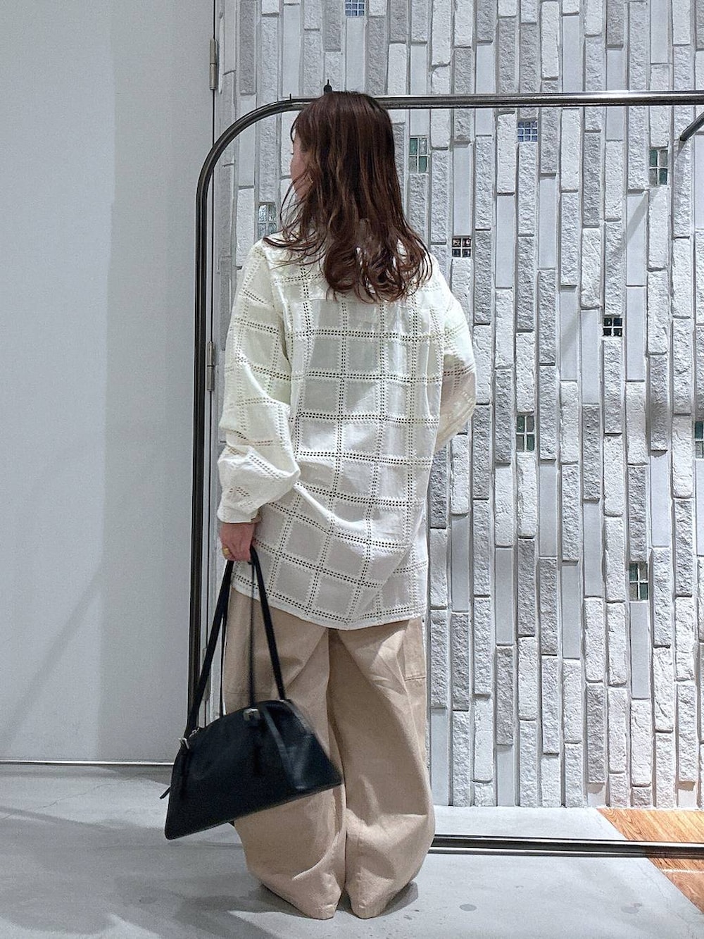 ブラック系のボストンバッグ、イエロー系のTシャツ/カットソー、ホワイト系のその他パンツを着用したレディースの冬コーディネートの4枚目の写真