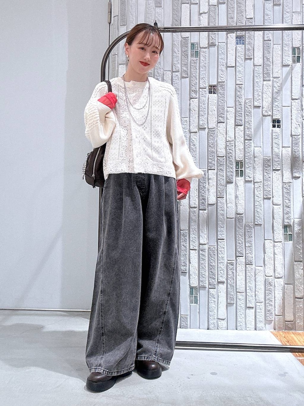 グレー系のTシャツ/カットソー、ブラウン系のサンダル、グレー系のデニムパンツを着用したレディースの冬コーディネートの2枚目の写真