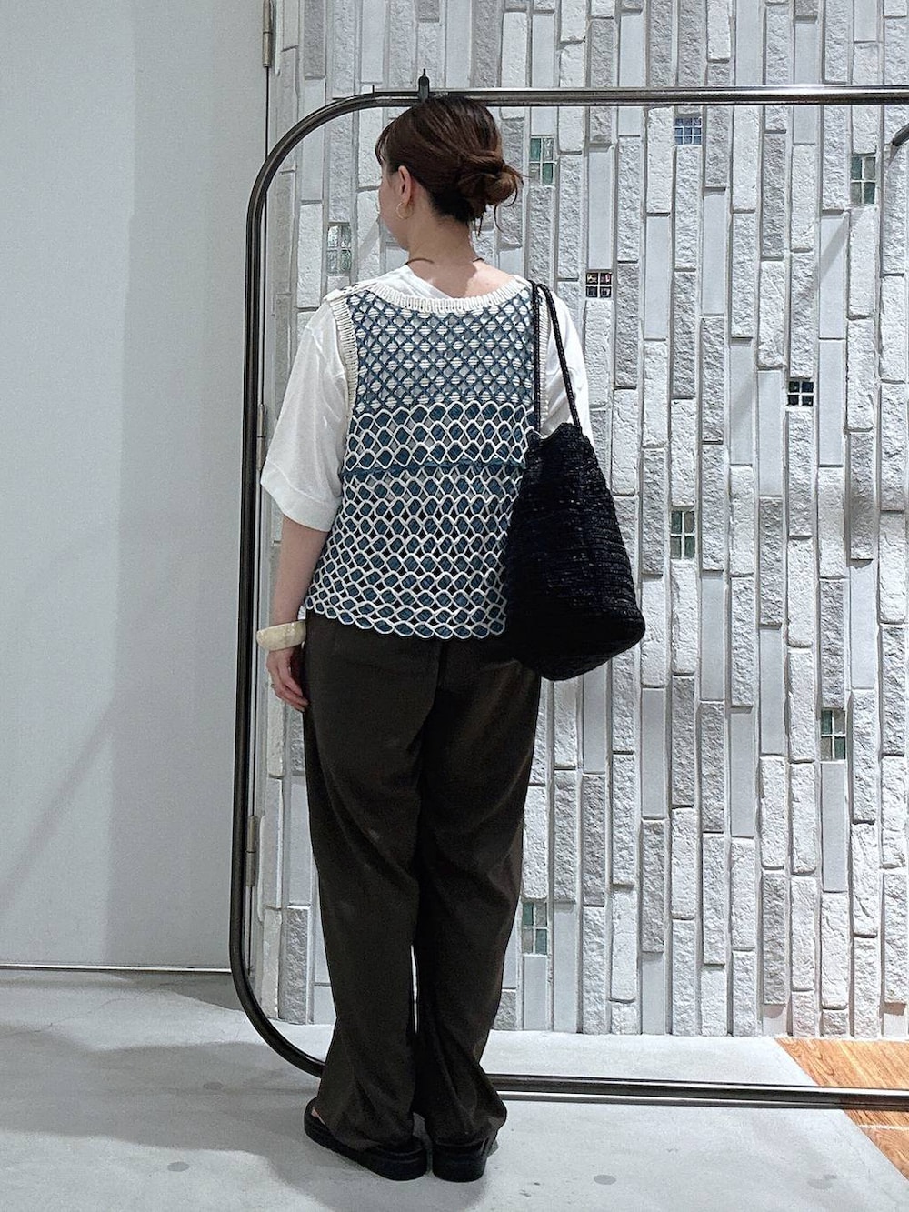 ブラウン系のその他パンツ、ブラック系のサンダル、ホワイト系のTシャツ/カットソーを着用したレディースの春コーディネートの4枚目の写真