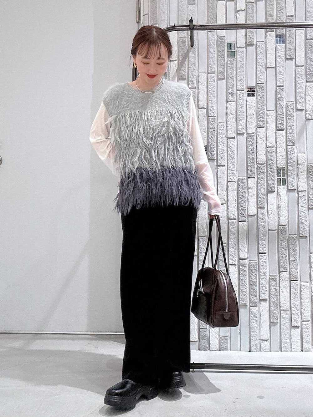 ホワイト系のTシャツ/カットソー、ブラック系のスカート、ブラック系のブーツを着用したレディースの冬コーディネートの2枚目の写真