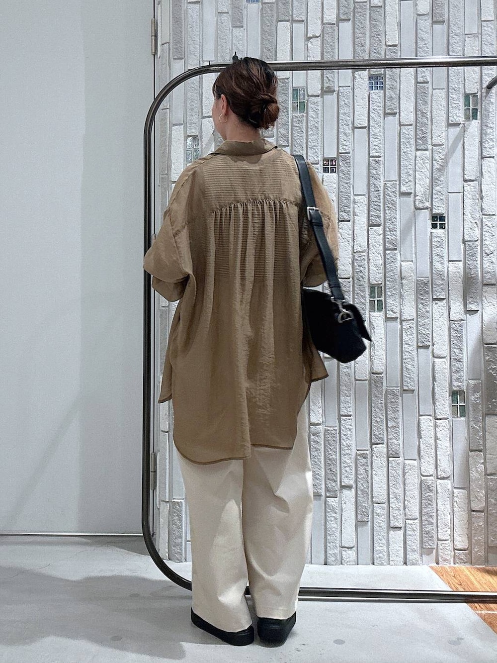 ブラウン系のシャツ/ブラウス、ブラック系のショルダーバッグ、ブラック系のサンダルを着用したレディースの夏コーディネートの4枚目の写真