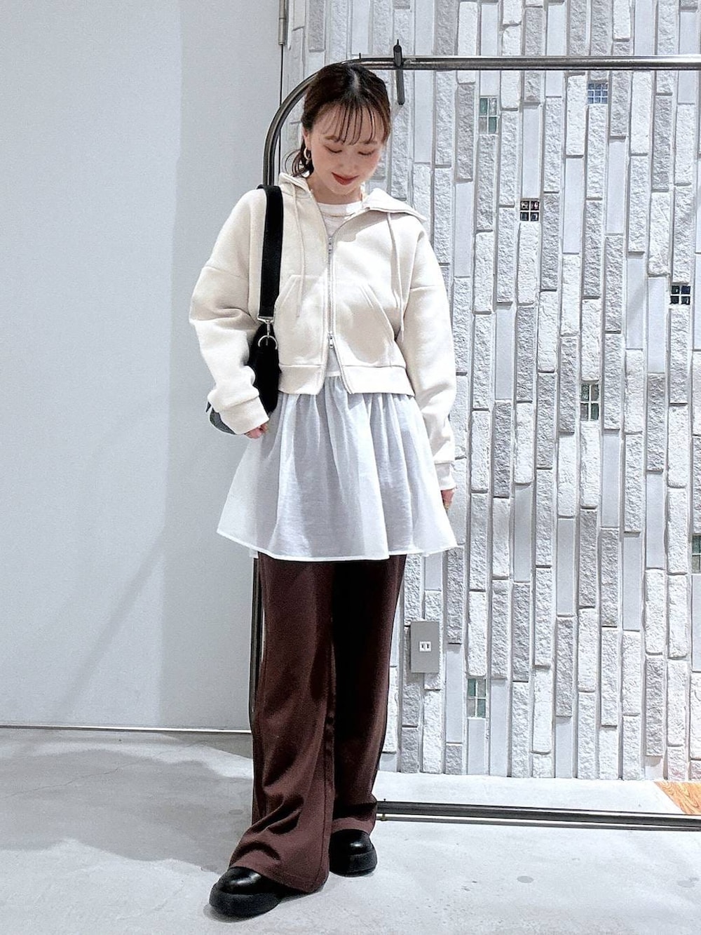 ブラック系のショルダーバッグ、ブラック系のサンダル、ホワイト系のTシャツ/カットソーを着用したレディースの冬コーディネートの2枚目の写真