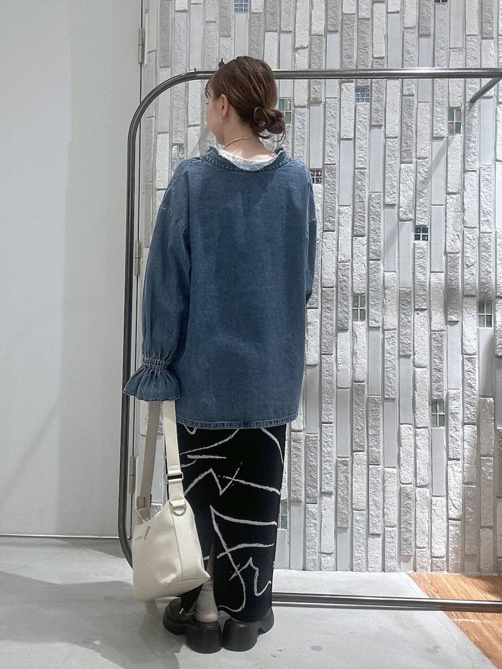 ホワイト系のショルダーバッグ、ブラウン系のサンダル、ブラック系のスカートを着用したレディースの冬コーディネートの4枚目の写真