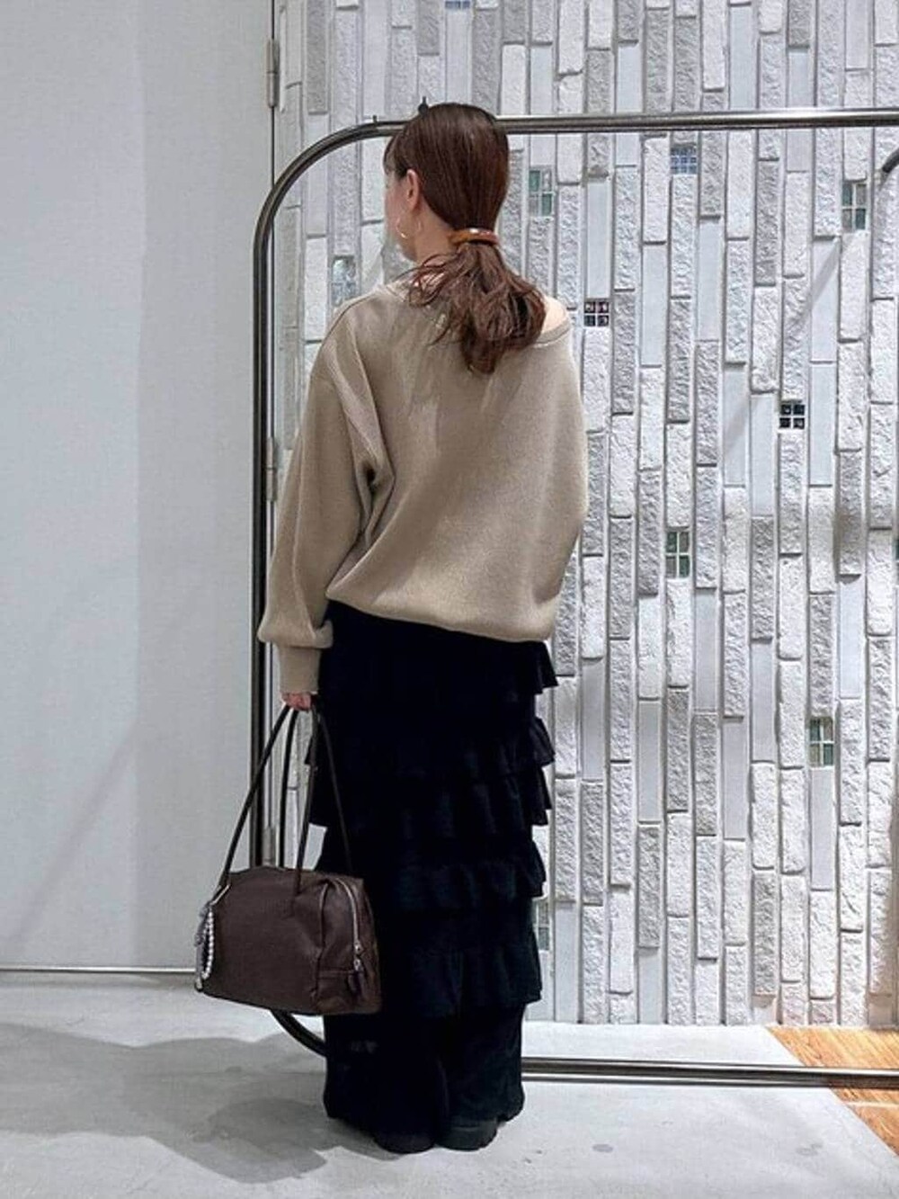 ブラウン系のボストンバッグ、ブラック系のその他シューズ、ブラック系のスカートを着用したレディースの春コーディネートの4枚目の写真