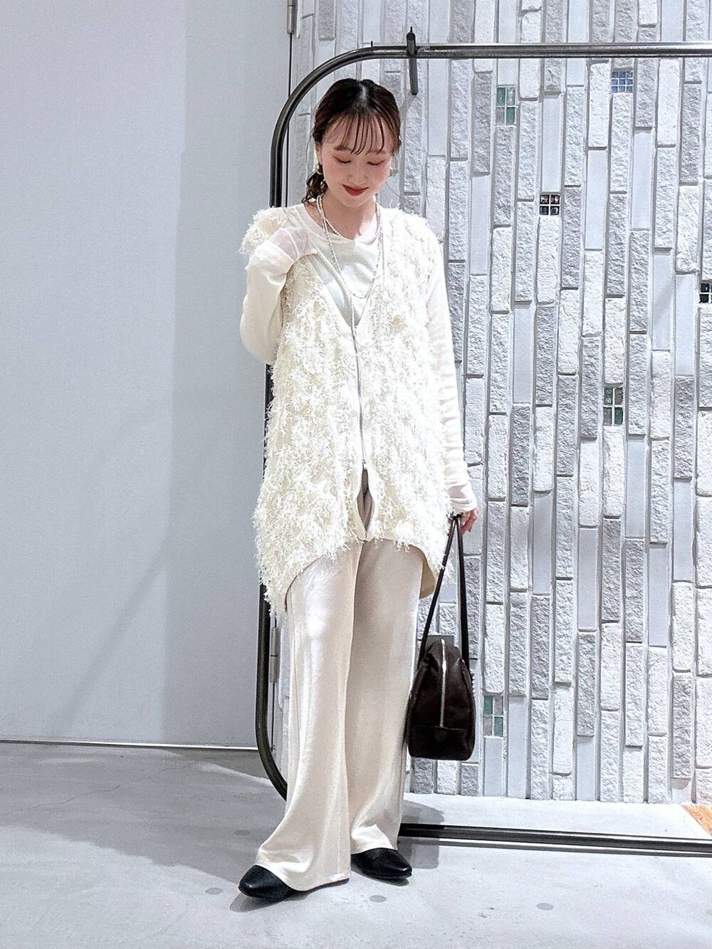 ホワイト系のTシャツ/カットソー、ブラウン系のボストンバッグ、ホワイト系のその他パンツを着用したレディースの春コーディネートの2枚目の写真