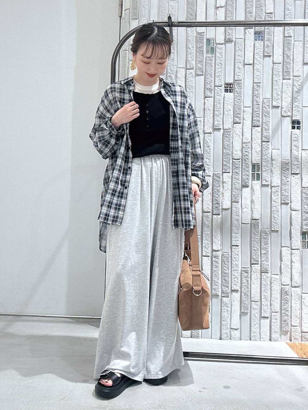 ホワイト系のTシャツ/カットソー、グレー系のその他パンツ、ブラウン系のショルダーバッグを着用したレディースの春コーディネートの2枚目の写真