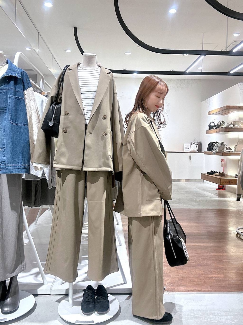 ブラウン系のその他パンツ、ブラウン系のテーラードジャケット、ブラック系のボストンバッグを着用したレディースの冬コーディネートの2枚目の写真