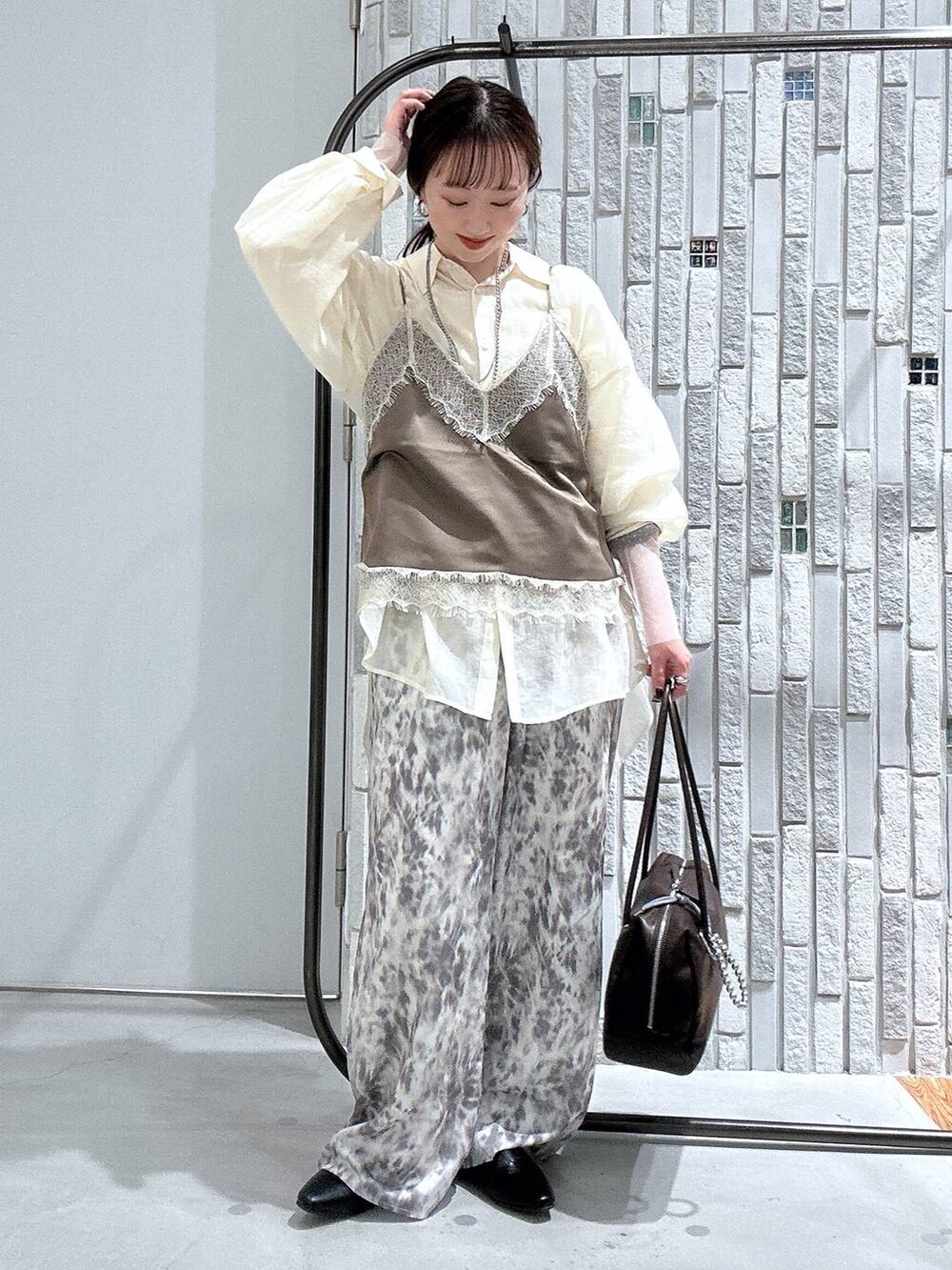 ホワイト系のシャツ/ブラウス、ホワイト系のTシャツ/カットソー、ブラウン系のボストンバッグを着用したレディースの春コーディネートの2枚目の写真