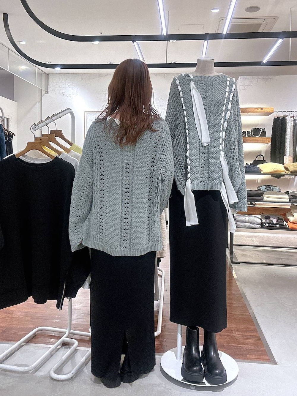 ブラック系のスカート、ブラウン系のブーツ、グリーン系のニット/セーターを着用したレディースの冬コーディネートの4枚目の写真