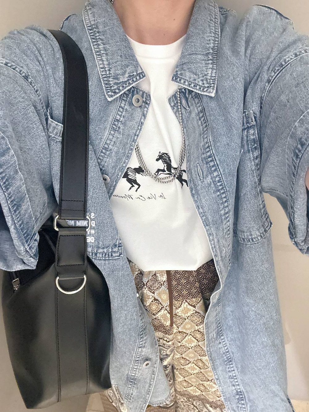 ブラック系のショルダーバッグ、ブルー系のシャツ/ブラウス、ブラック系のパンプスを着用したレディースの春コーディネートの5枚目の写真
