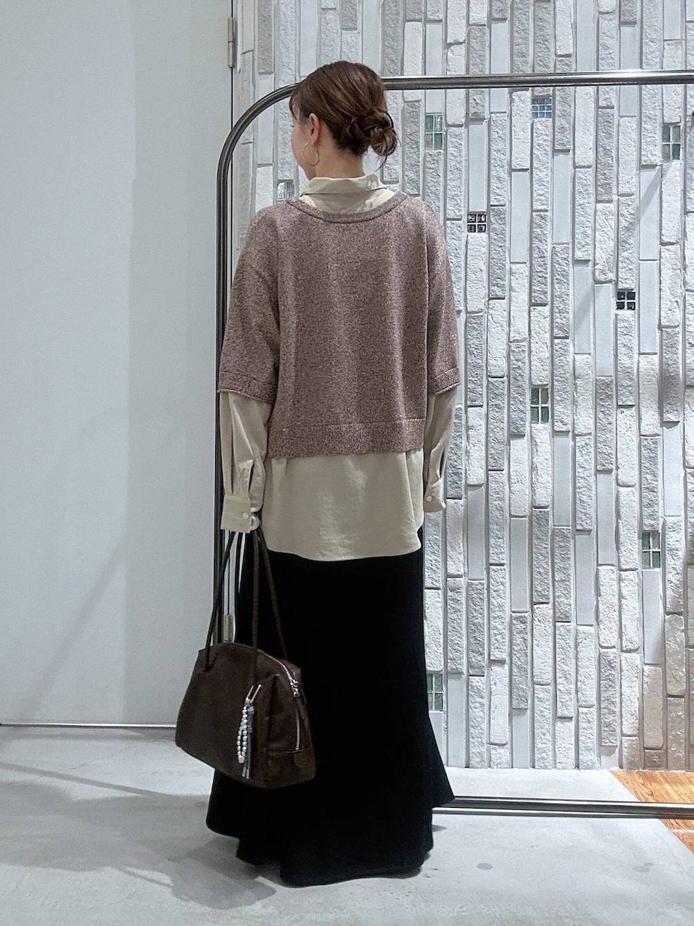 ブラック系のブーツ、ブラック系のスカート、ブラウン系のボストンバッグを着用したレディースの冬コーディネートの4枚目の写真