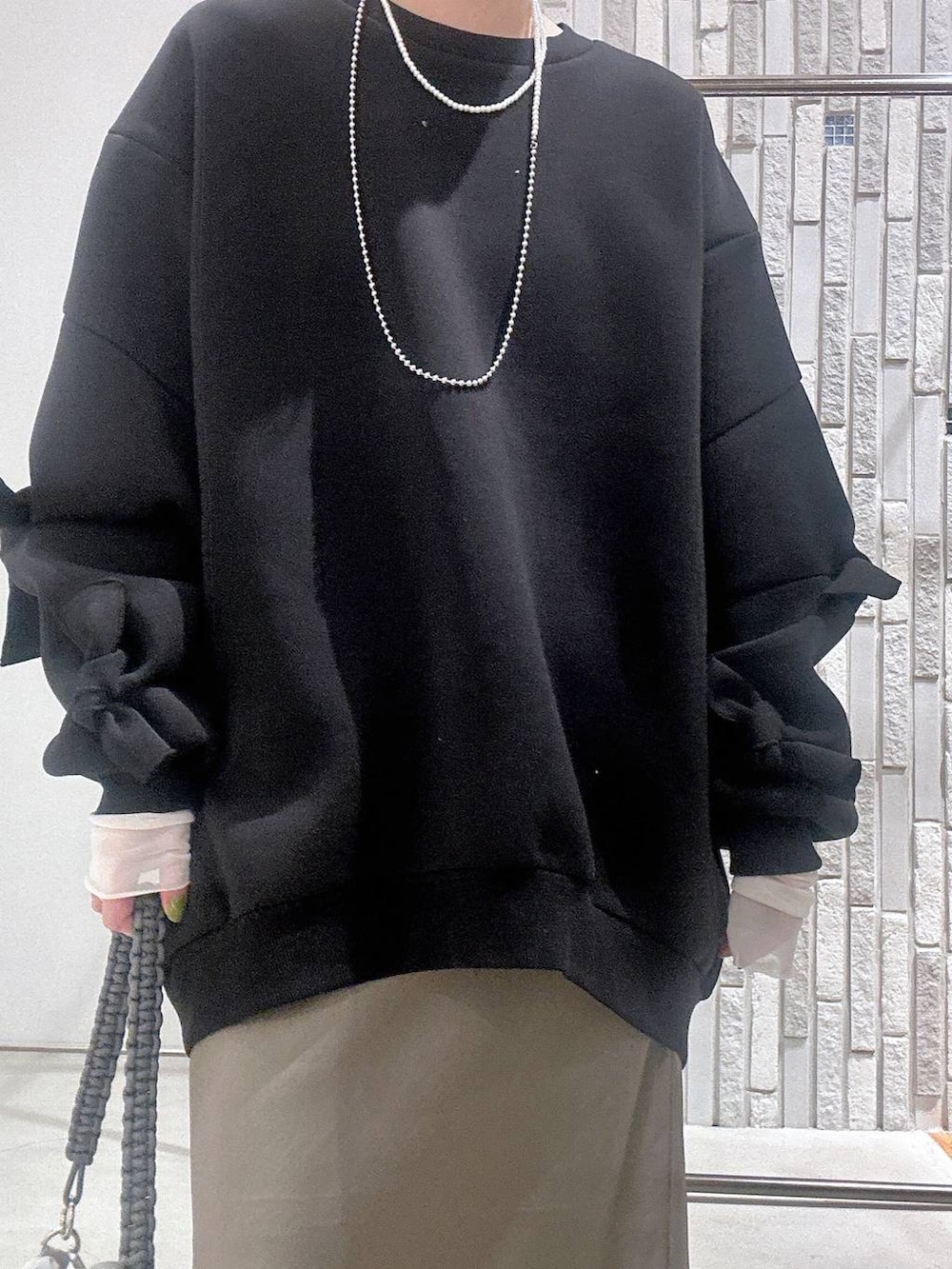 グリーン系のスカート、ブラック系のスウェット、ホワイト系のTシャツ/カットソーを着用したレディースの冬コーディネートの5枚目の写真