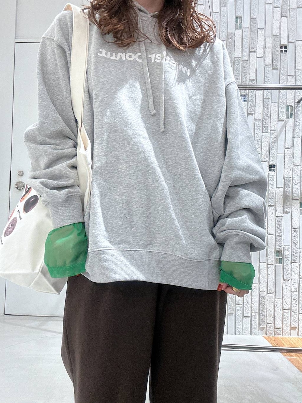 ブラック系のTシャツ/カットソー、ブラック系のブーツ、グレー系のパーカーを着用したレディースの冬コーディネートの5枚目の写真