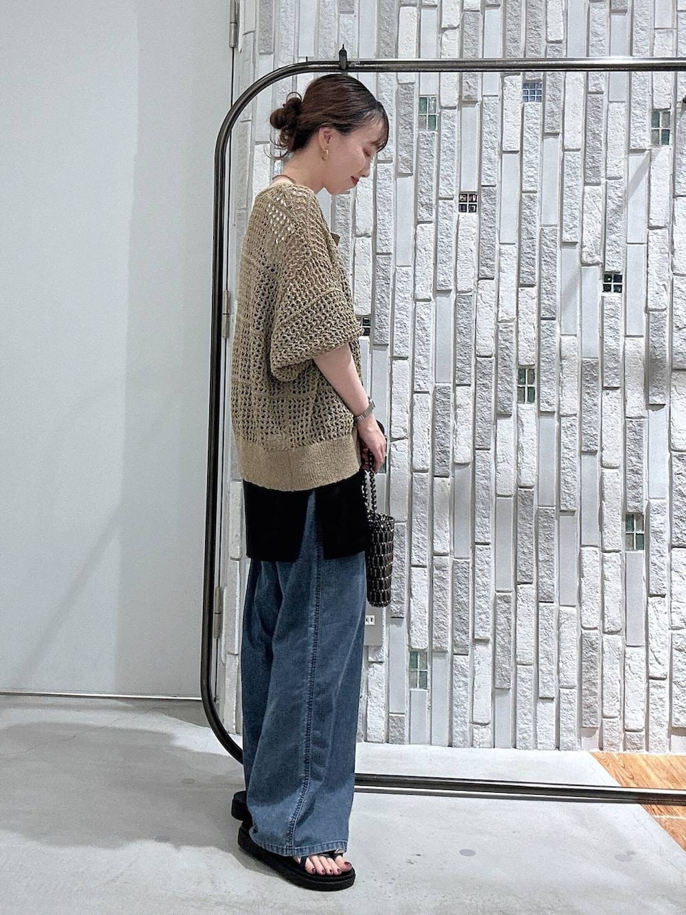 ブルー系のデニムパンツ、その他のショルダーバッグ、ブラック系のキャミソールを着用したレディースの春コーディネートの3枚目の写真
