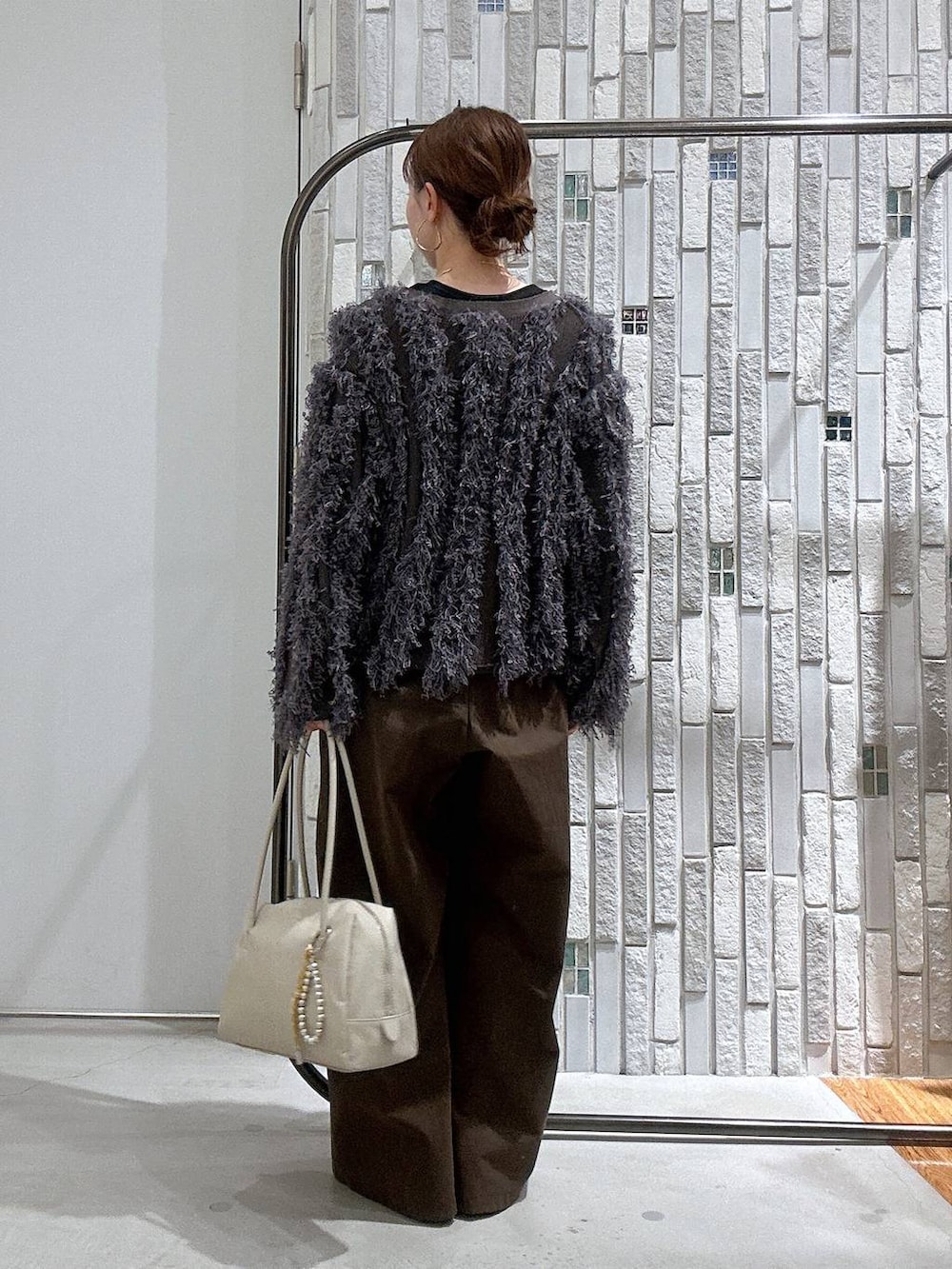 ブラック系のブーツ、ブラック系のTシャツ/カットソー、ホワイト系のボストンバッグを着用したレディースの冬コーディネートの4枚目の写真