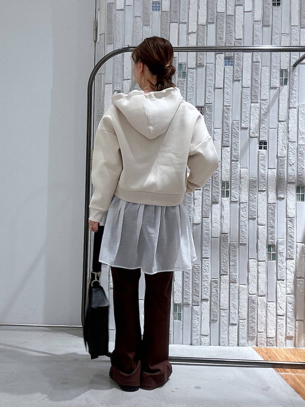 ブラック系のショルダーバッグ、ブラック系のサンダル、ホワイト系のTシャツ/カットソーを着用したレディースの冬コーディネートの4枚目の写真