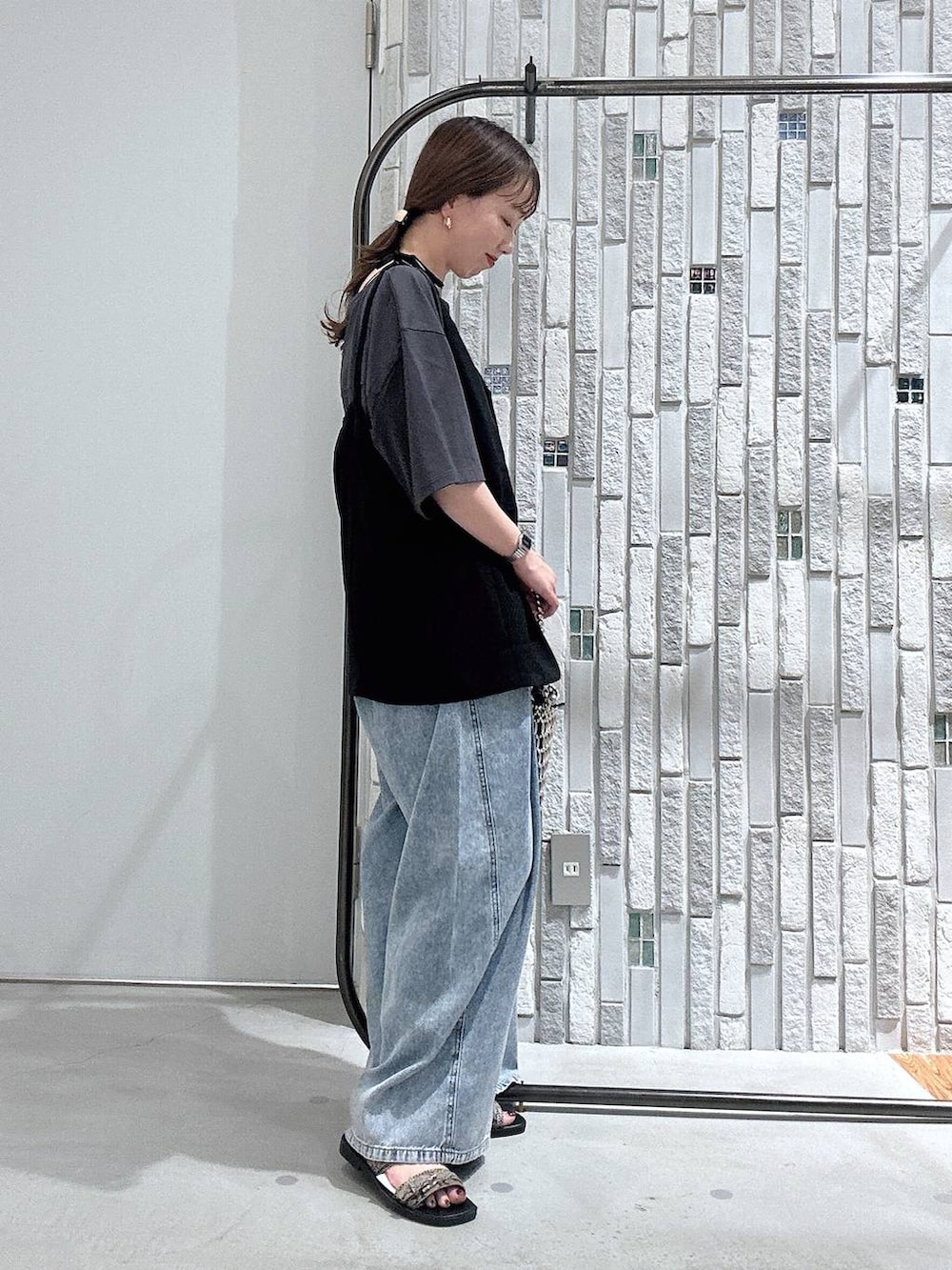 グレー系のTシャツ/カットソー、ブルー系のデニムパンツ、シルバー系のショルダーバッグを着用したレディースの夏コーディネートの3枚目の写真