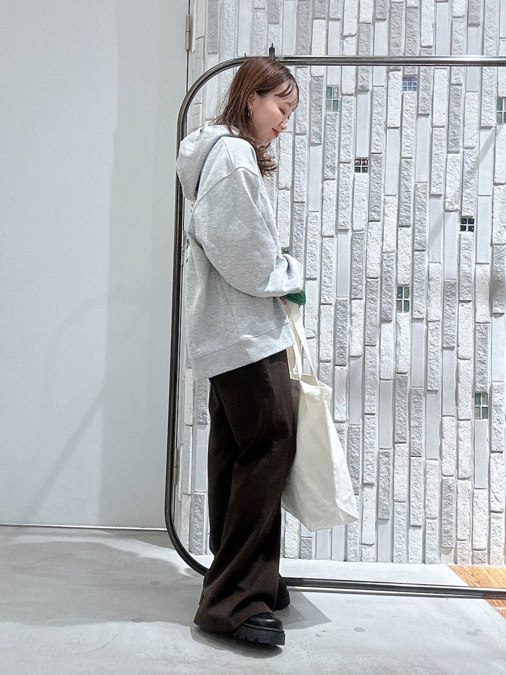 ブラック系のTシャツ/カットソー、ブラック系のブーツ、グレー系のパーカーを着用したレディースの冬コーディネートの3枚目の写真