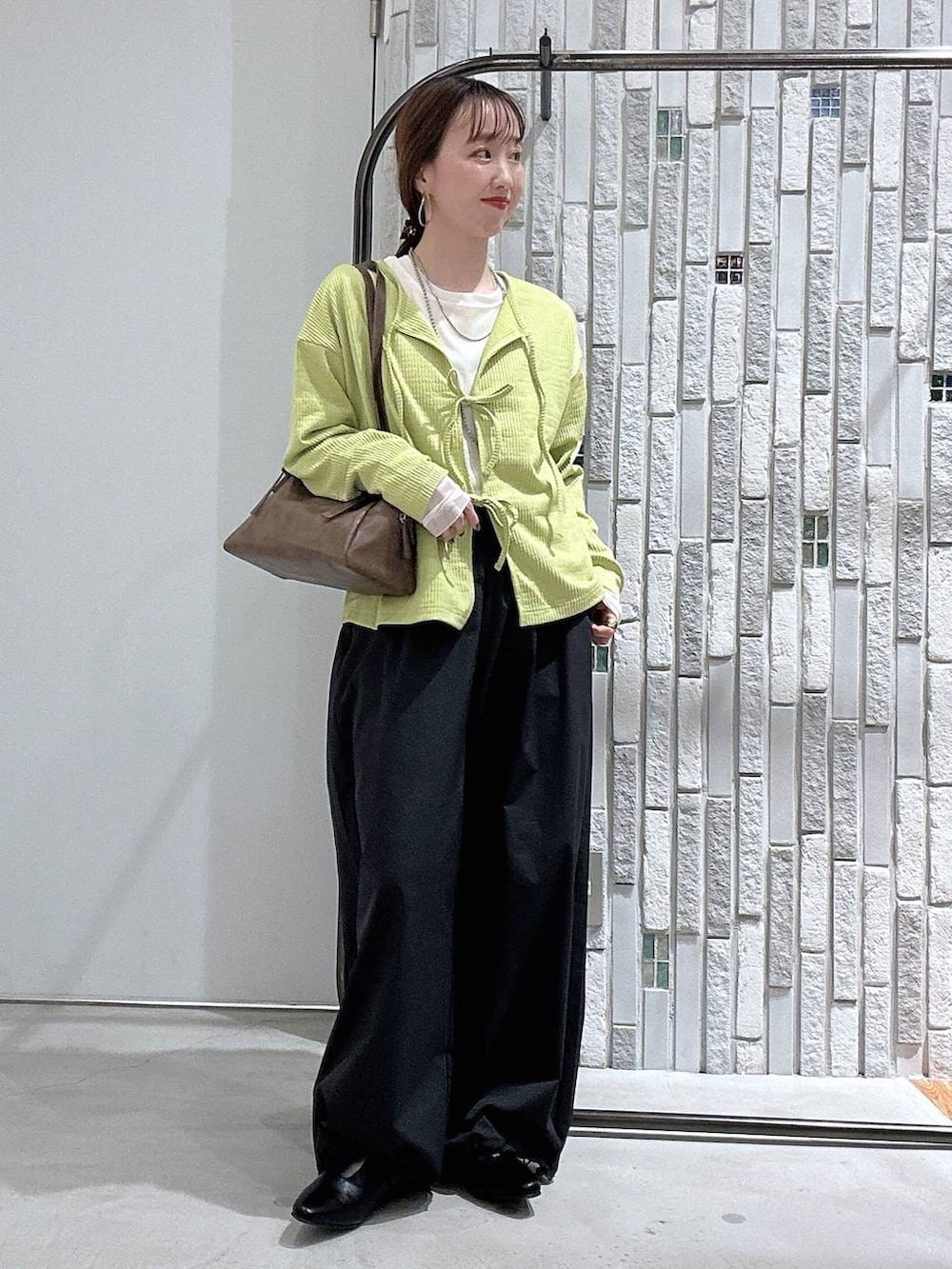 ブラウン系のボストンバッグ、ホワイト系のTシャツ/カットソー、グレー系のその他パンツを着用したレディースの春コーディネートの2枚目の写真