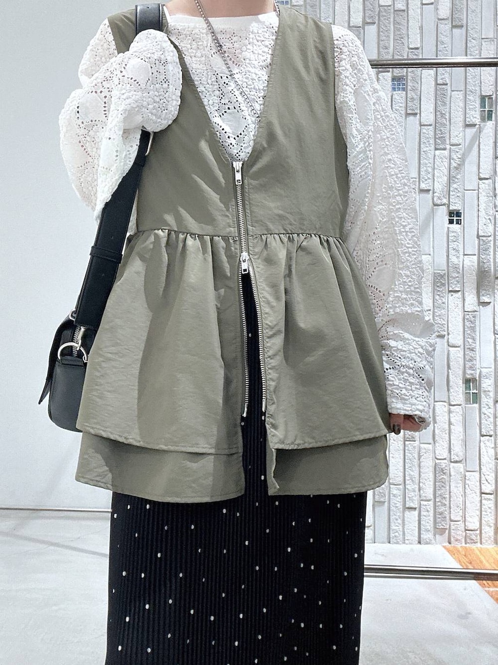 ブラック系のショルダーバッグ、ブラウン系のサンダル、ホワイト系のTシャツ/カットソーを着用したレディースの春コーディネートの5枚目の写真