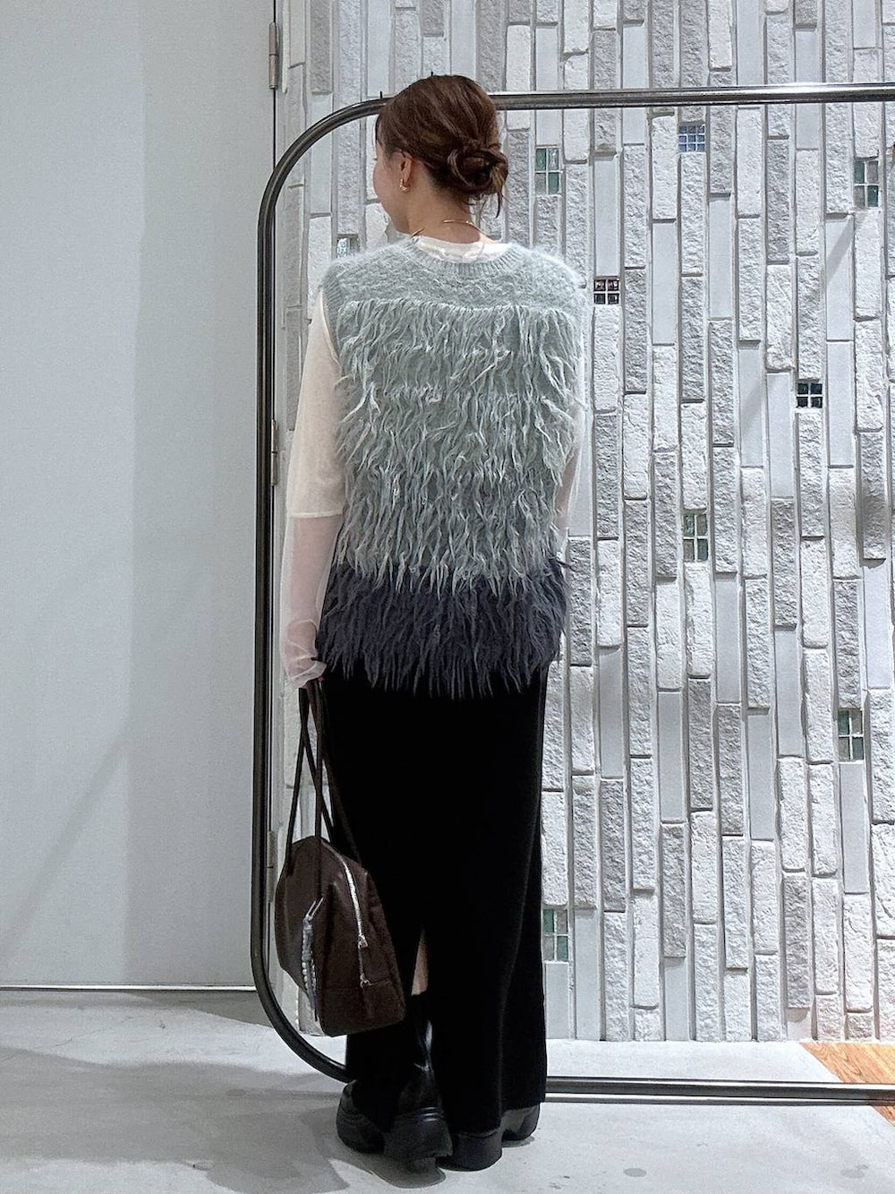 ホワイト系のTシャツ/カットソー、ブラック系のスカート、ブラック系のブーツを着用したレディースの冬コーディネートの4枚目の写真