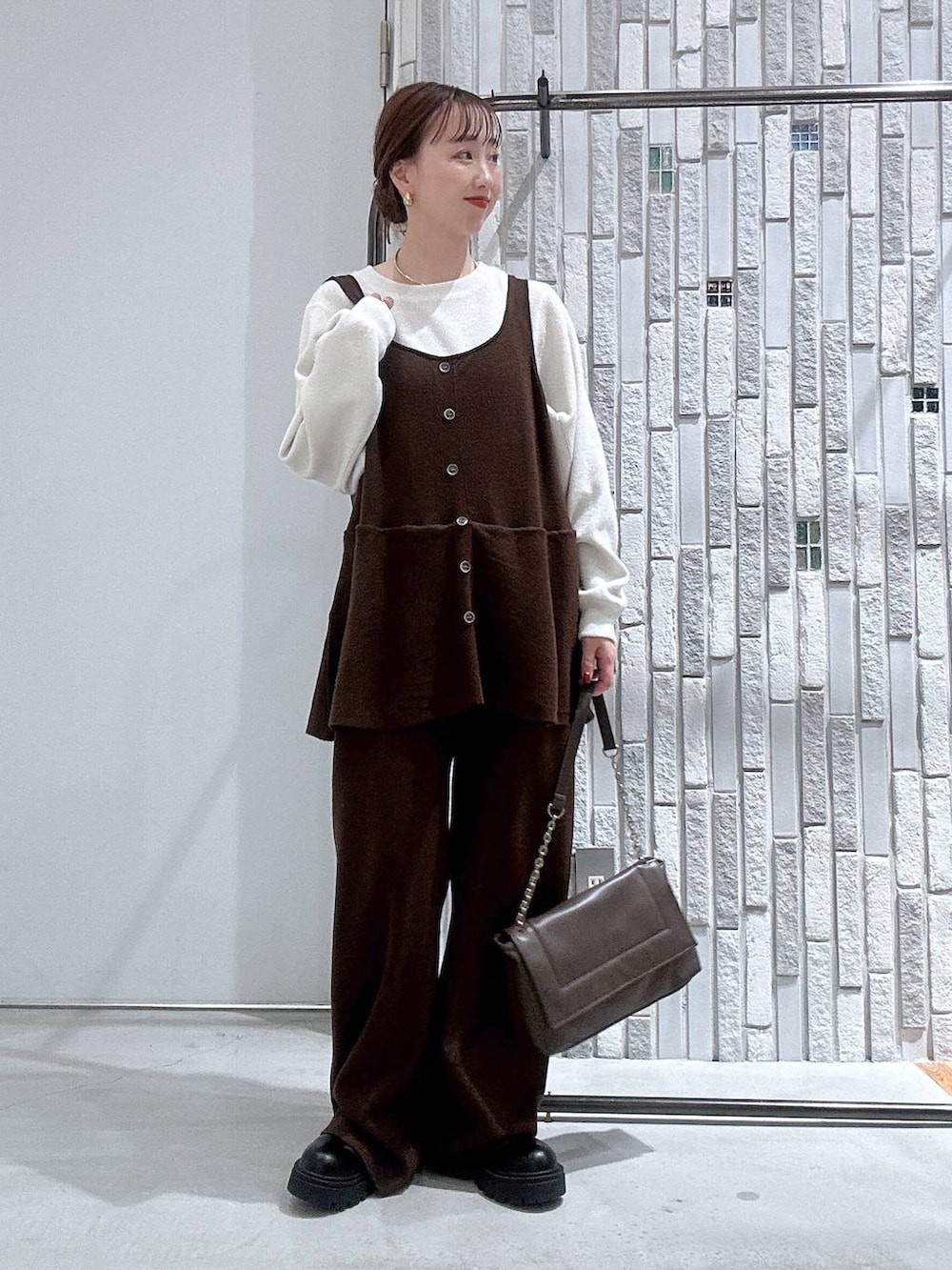 ブラック系のブーツ、ホワイト系のTシャツ/カットソー、ブラウン系のショルダーバッグを着用したレディースの冬コーディネートの3枚目の写真