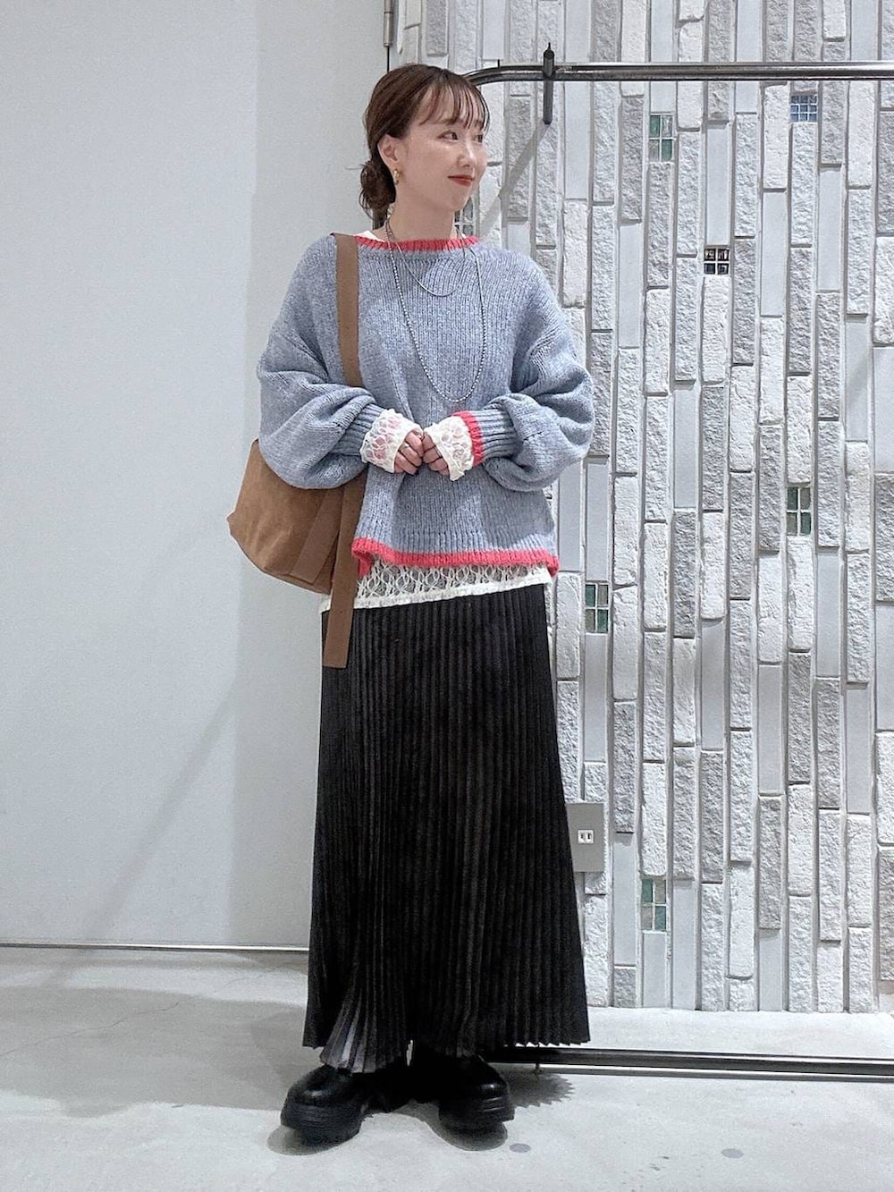 ブラウン系のショルダーバッグ、グレー系のスカート、ブラック系のブーツを着用したレディースの冬コーディネートの2枚目の写真