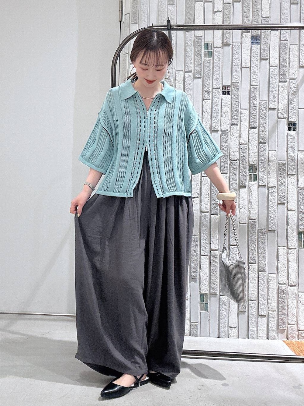 シルバー系のショルダーバッグ、ブラック系のパンプス、グレー系のその他パンツを着用したレディースの春コーディネートの2枚目の写真