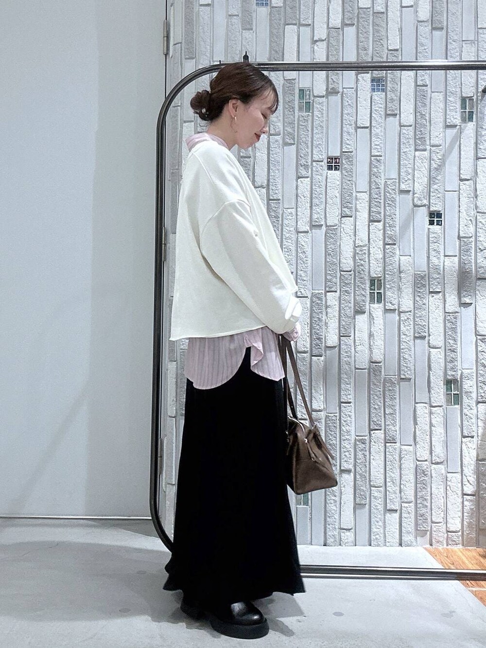 ブラック系のサンダル、ブラウン系のボストンバッグ、ピンク系のシャツ/ブラウスを着用したレディースの冬コーディネートの4枚目の写真