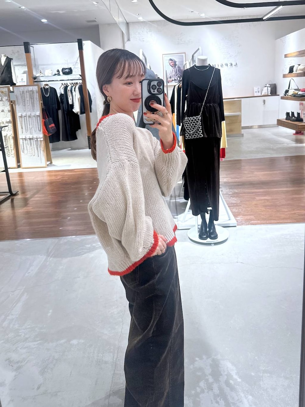 ブラウン系のデニムパンツ、ベージュ系のニット/セーターを着用したレディースの冬コーディネートの3枚目の写真