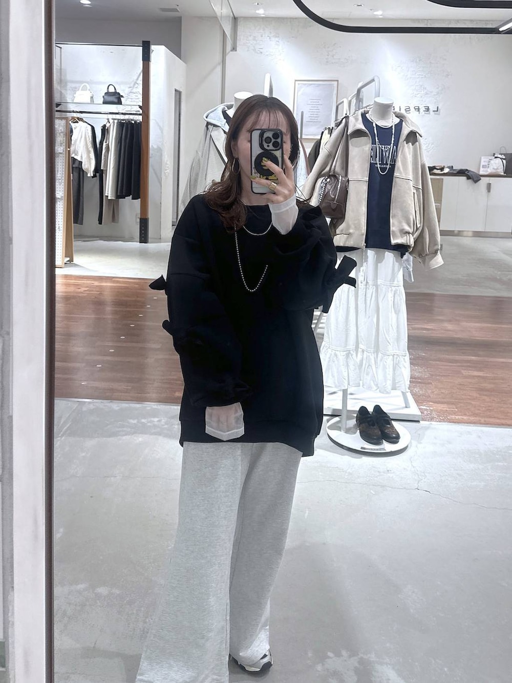 ブラック系のスウェット、ホワイト系のTシャツ/カットソー、グレー系のスウェットパンツを着用したレディースの冬コーディネートの3枚目の写真