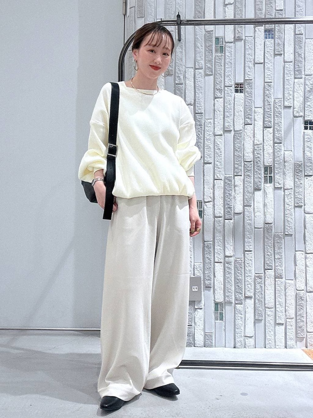 ブラック系のショルダーバッグ、ホワイト系のその他パンツ、ホワイト系のTシャツ/カットソーを着用したレディースの冬コーディネートの2枚目の写真