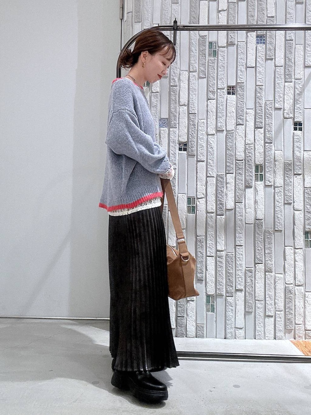 ブラウン系のショルダーバッグ、グレー系のスカート、ブラック系のブーツを着用したレディースの冬コーディネートの3枚目の写真