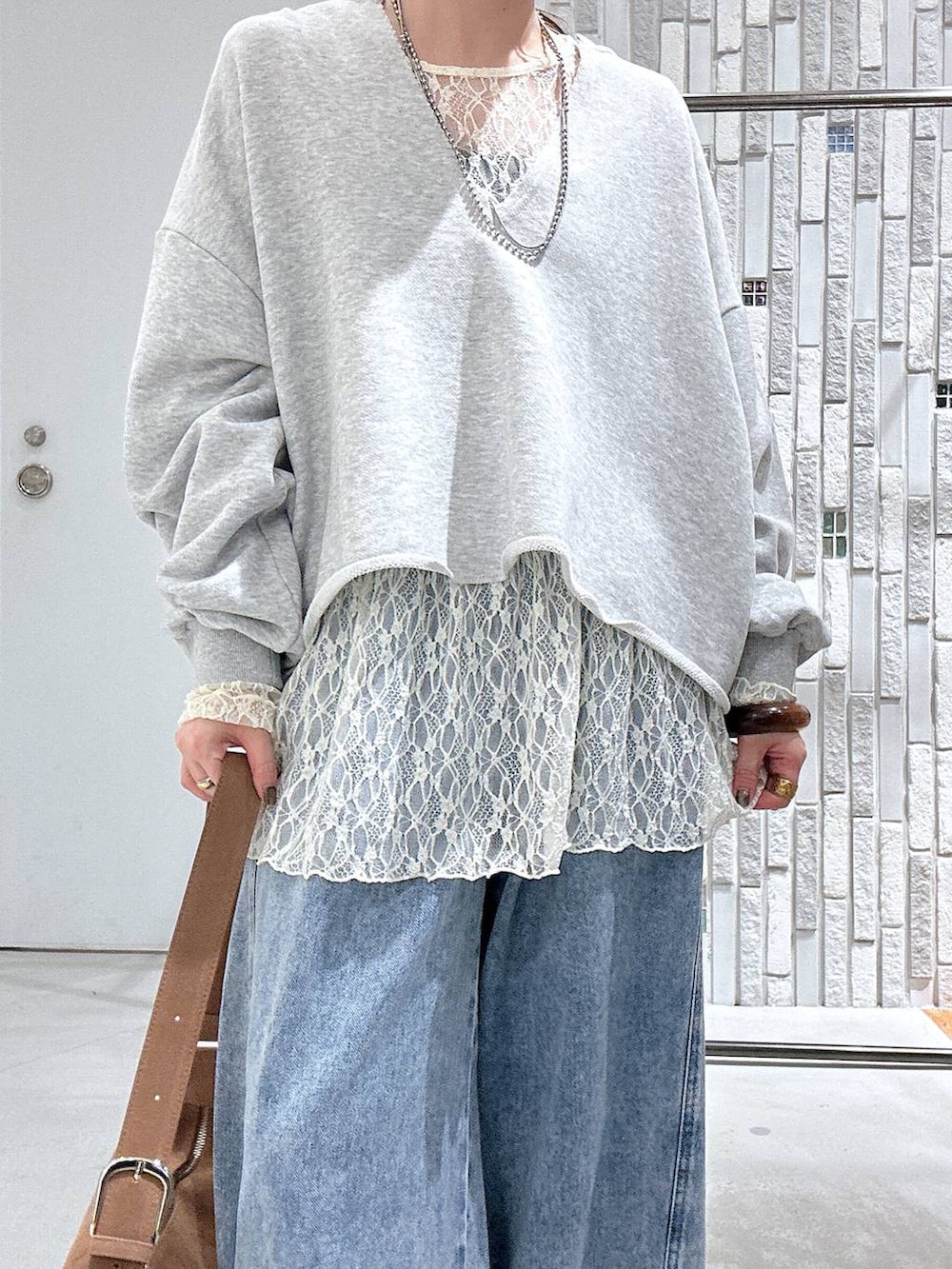 ブラウン系のショルダーバッグ、ブルー系のデニムパンツ、ブラック系のその他シューズを着用したレディースの春コーディネートの5枚目の写真