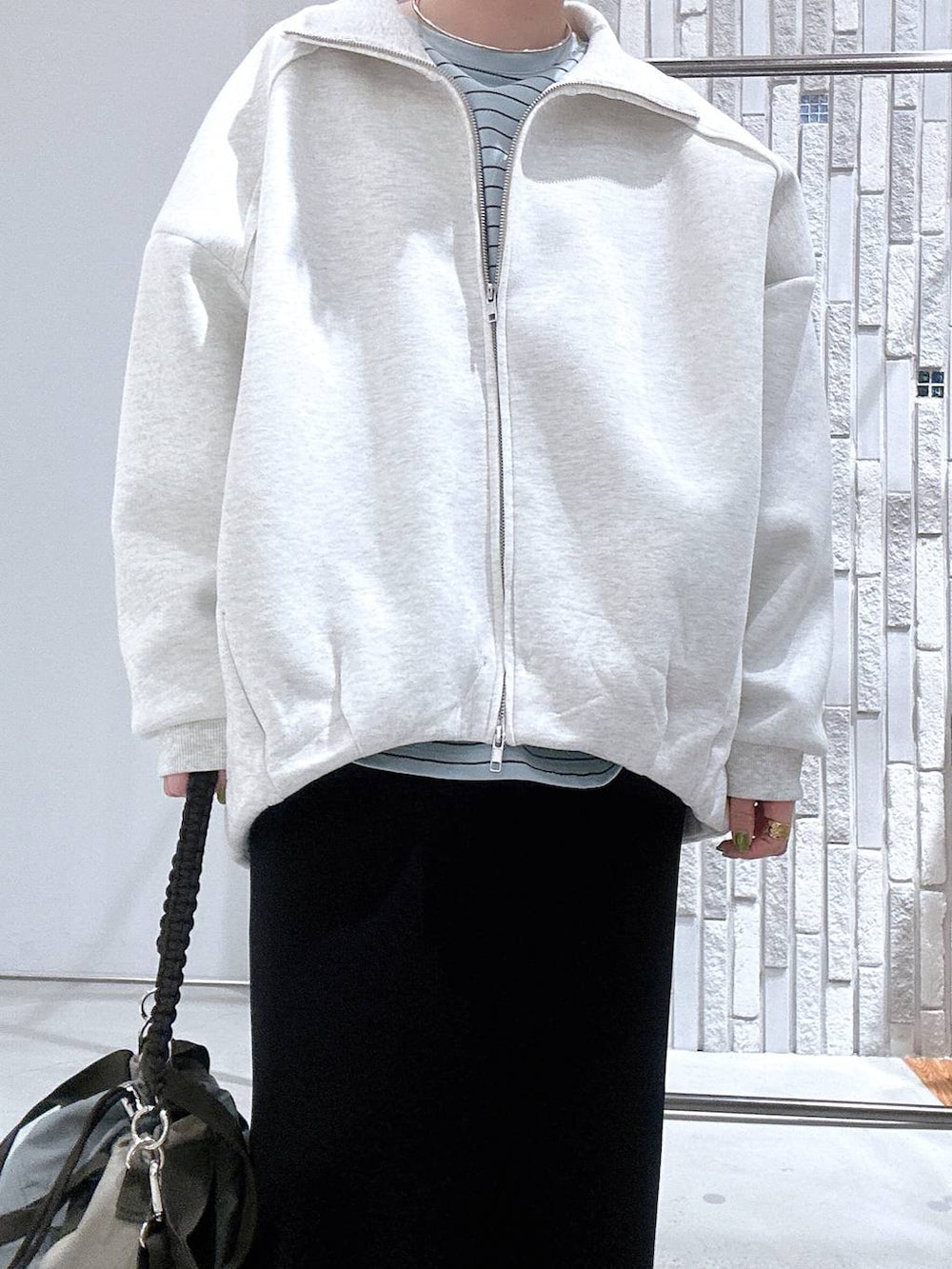 ブラック系のスカート、ブラック系のサンダル、グリーン系のショルダーバッグを着用したレディースの冬コーディネートの5枚目の写真