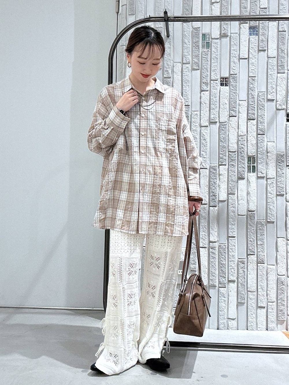 ブラウン系のボストンバッグ、ホワイト系のその他パンツ、ブラック系のパンプスを着用したレディースの春コーディネートの2枚目の写真