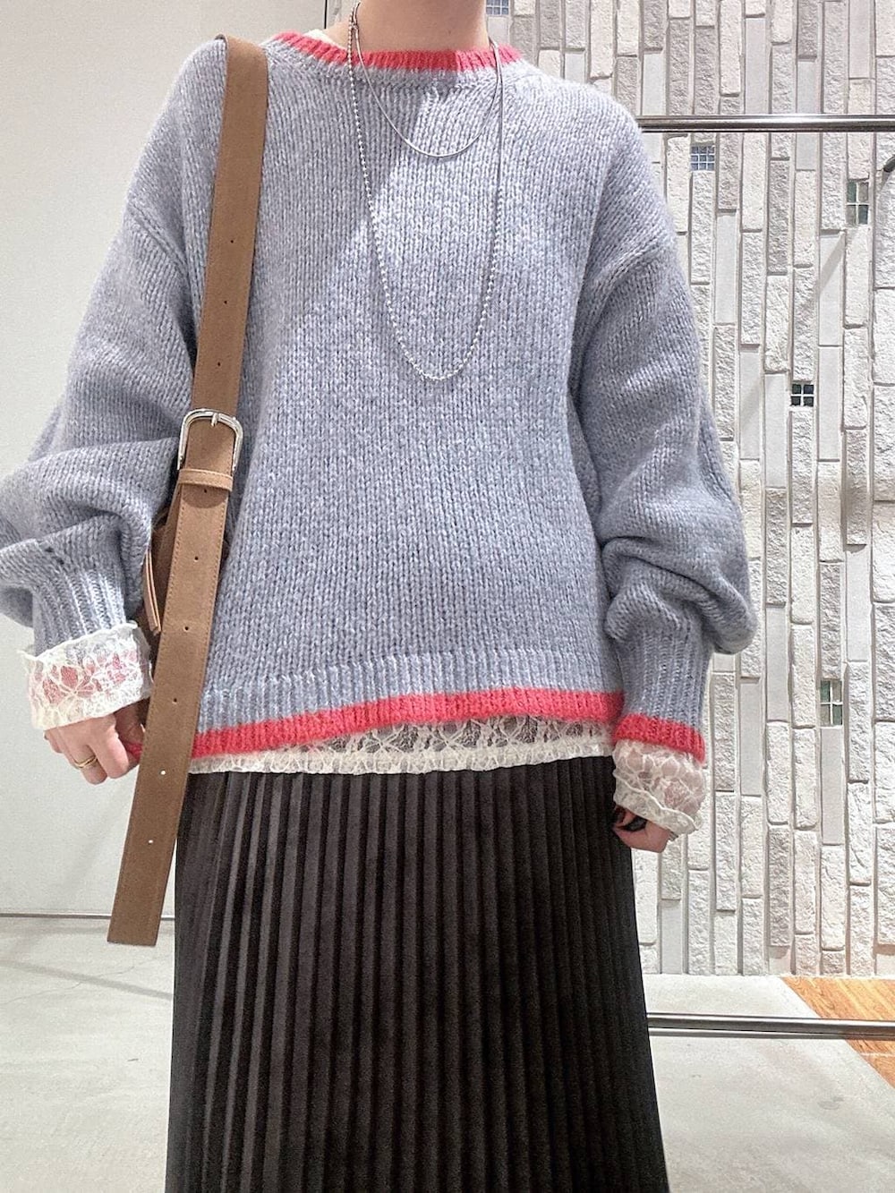 ブラウン系のショルダーバッグ、グレー系のスカート、ブラック系のブーツを着用したレディースの冬コーディネートの5枚目の写真