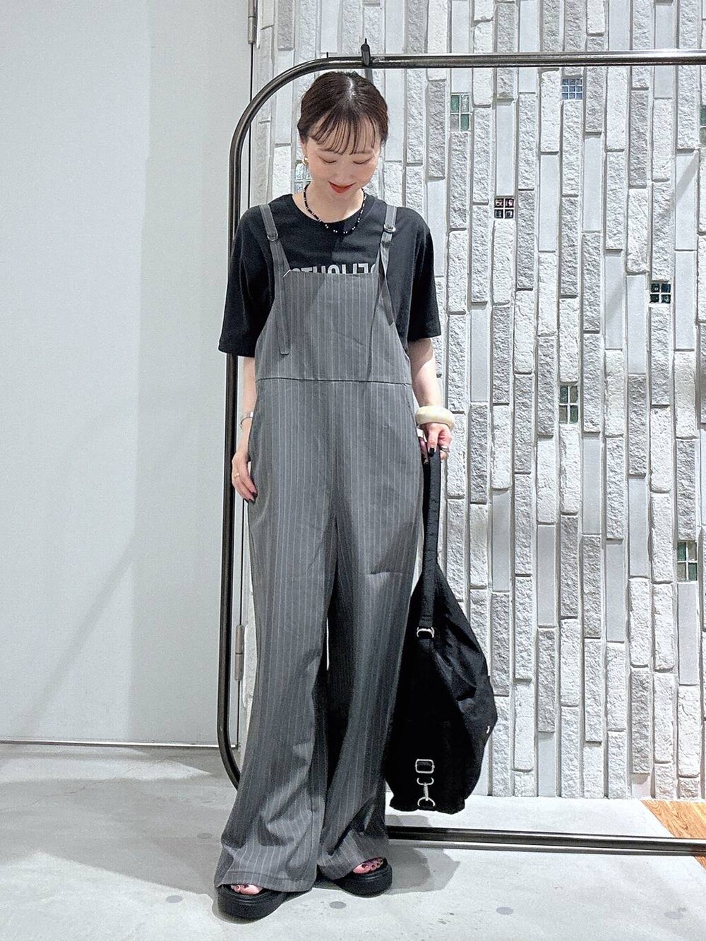 グレー系のサロペット/オーバーオール、グレー系のTシャツ/カットソー、ブラック系のショルダーバッグを着用したレディースの夏コーディネートの2枚目の写真