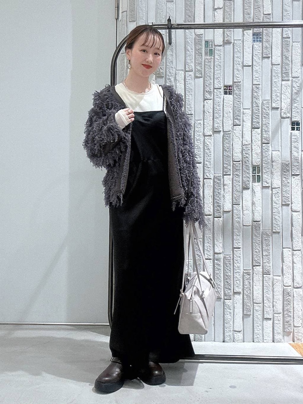 ブラウン系のサンダル、グレー系のボストンバッグ、ホワイト系のTシャツ/カットソーを着用したレディースの冬コーディネートの2枚目の写真