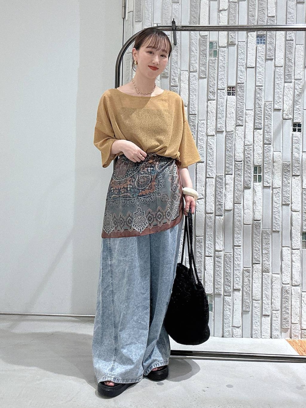 ブルー系のデニムパンツ、ブラック系のサンダル、グレー系のショルダーバッグを着用したレディースの春コーディネートの5枚目の写真