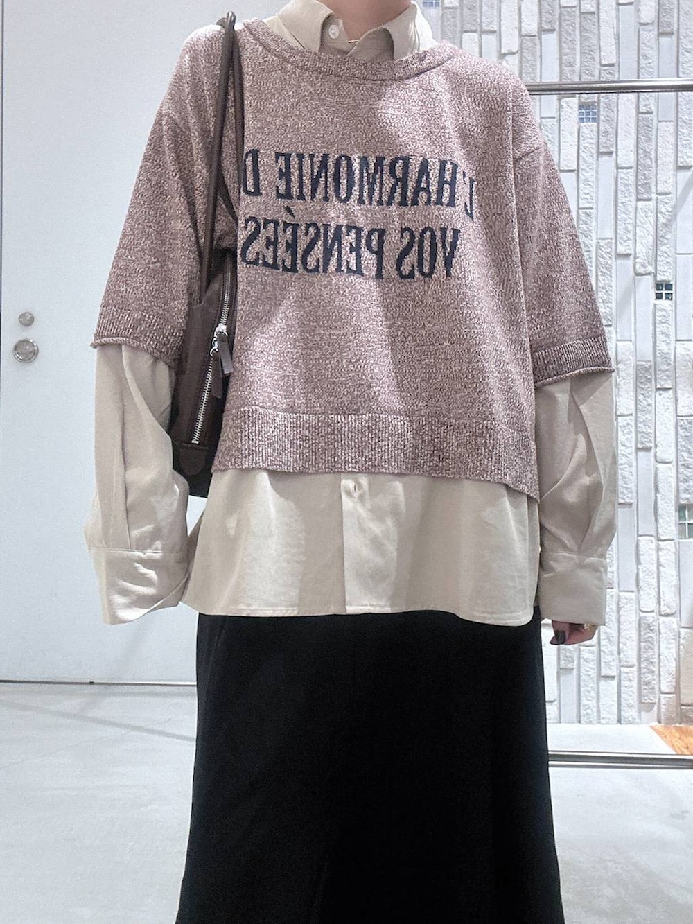 ブラック系のブーツ、ブラック系のスカート、ブラウン系のボストンバッグを着用したレディースの冬コーディネートの5枚目の写真