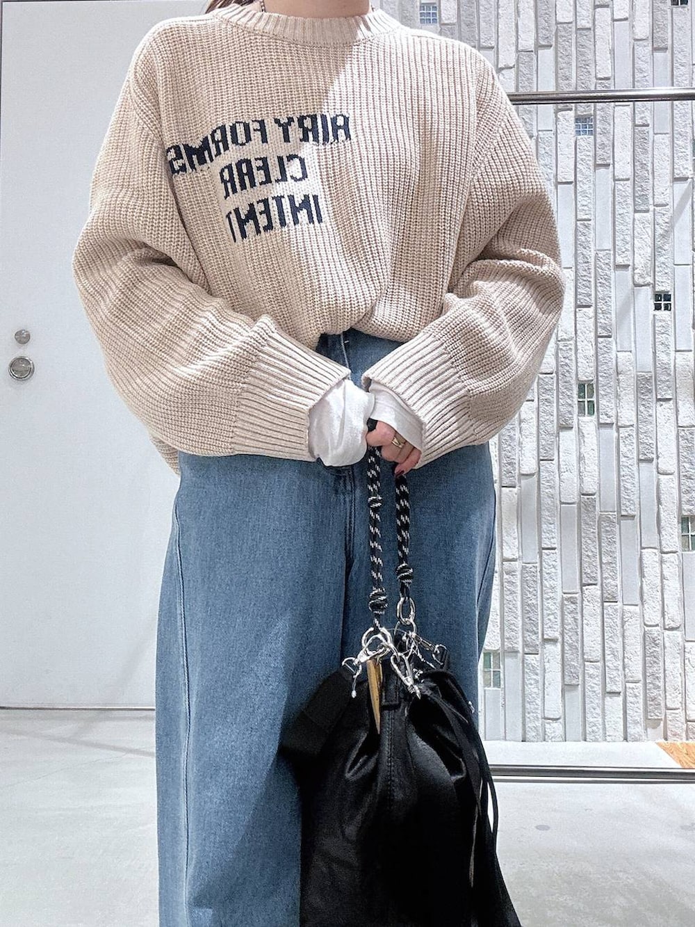 ブラック系のショルダーバッグ、グレー系のその他アウター、ブルー系のデニムパンツを着用したレディースの冬コーディネートの7枚目の写真