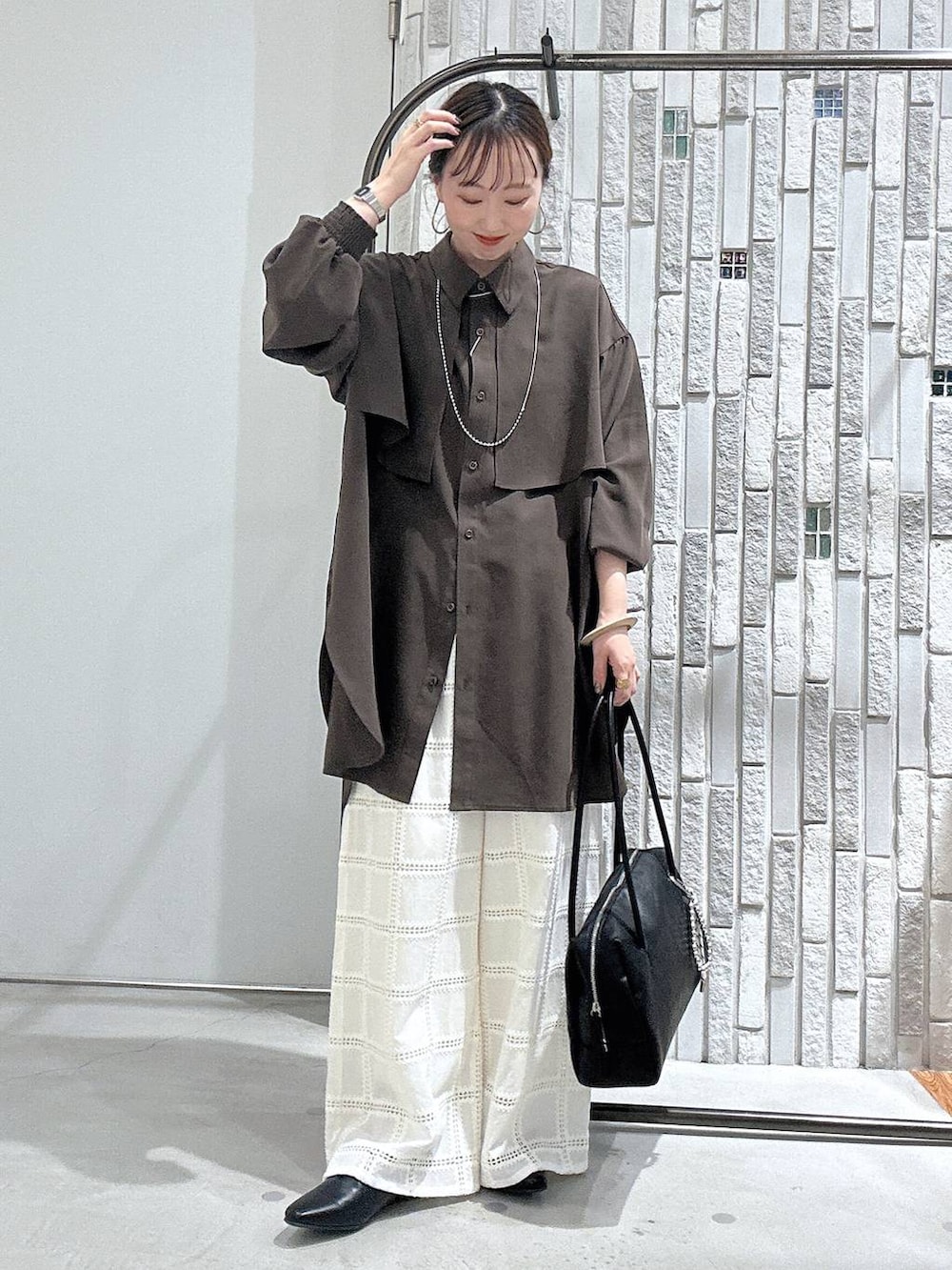 ブラウン系のシャツ/ブラウス、ブラック系のボストンバッグ、ホワイト系のその他パンツを着用したレディースの冬コーディネートの2枚目の写真