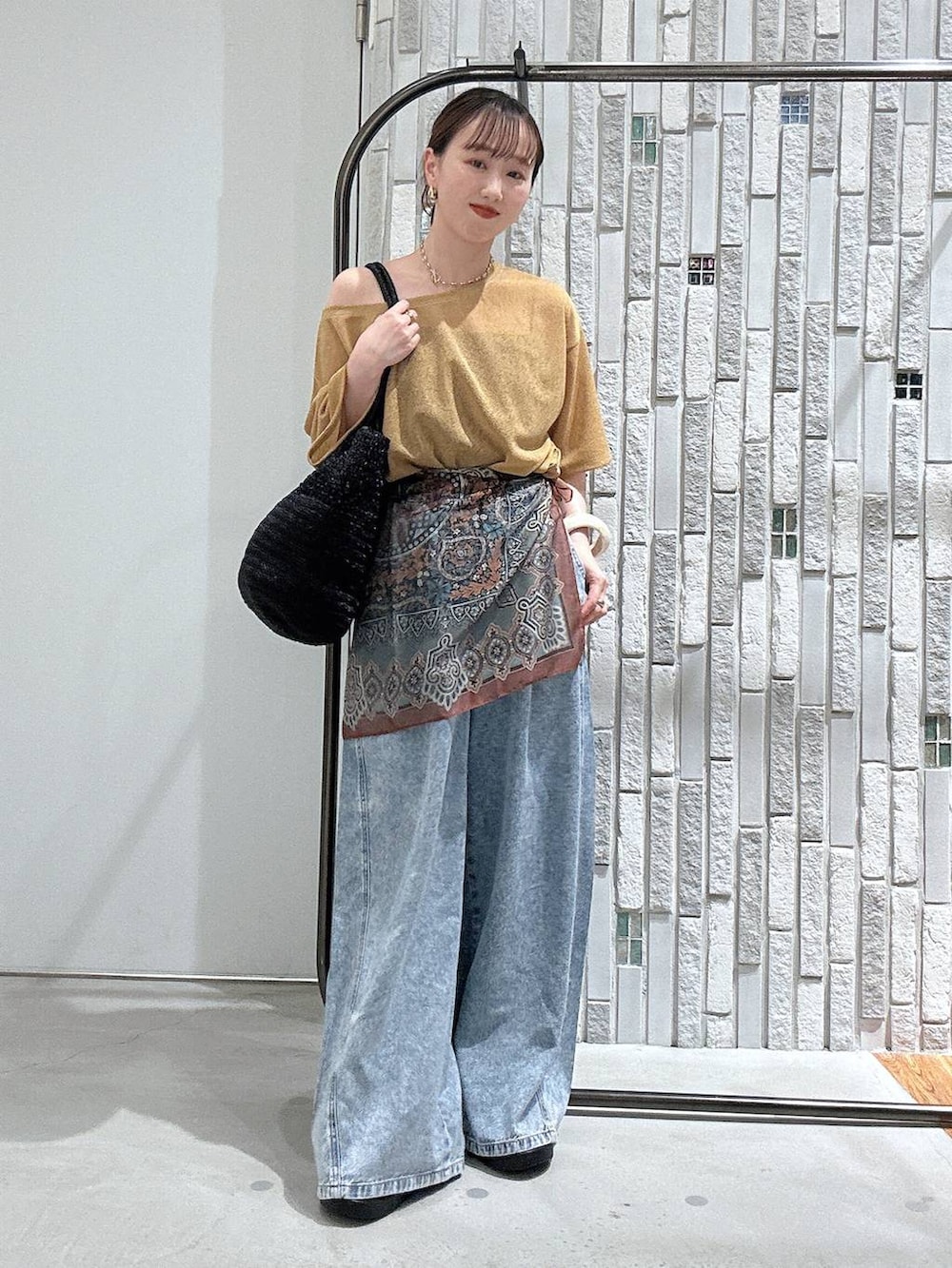 ブルー系のデニムパンツ、ブラック系のサンダル、グレー系のショルダーバッグを着用したレディースの春コーディネートの2枚目の写真