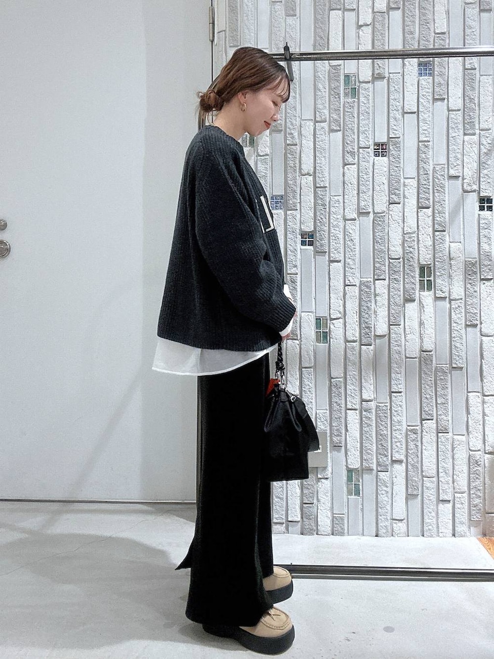 ブラック系のショルダーバッグ、ブラック系のスカート、ホワイト系のTシャツ/カットソーを着用したレディースの冬コーディネートの4枚目の写真