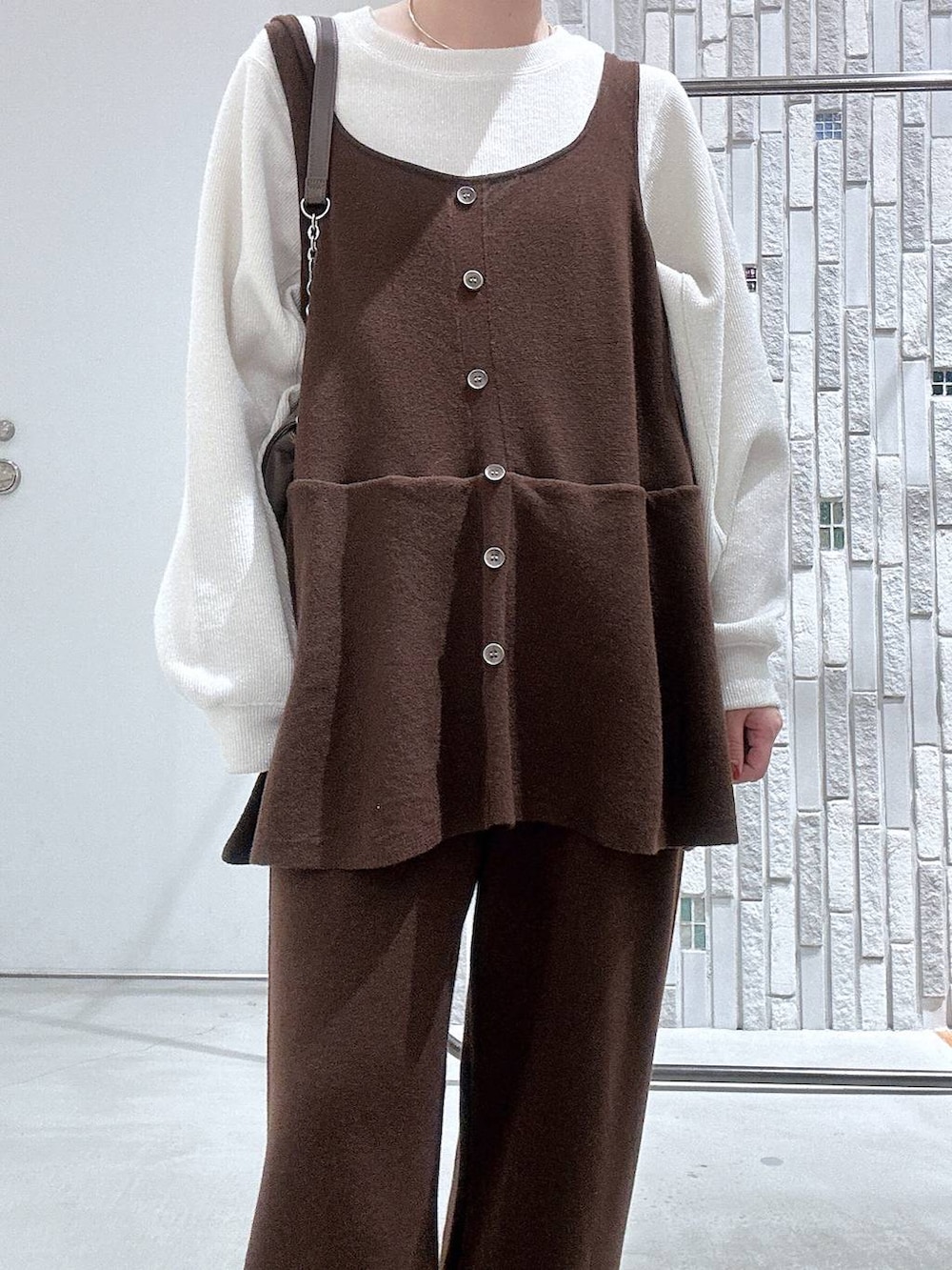 ブラック系のブーツ、ホワイト系のTシャツ/カットソー、ブラウン系のショルダーバッグを着用したレディースの冬コーディネートの6枚目の写真