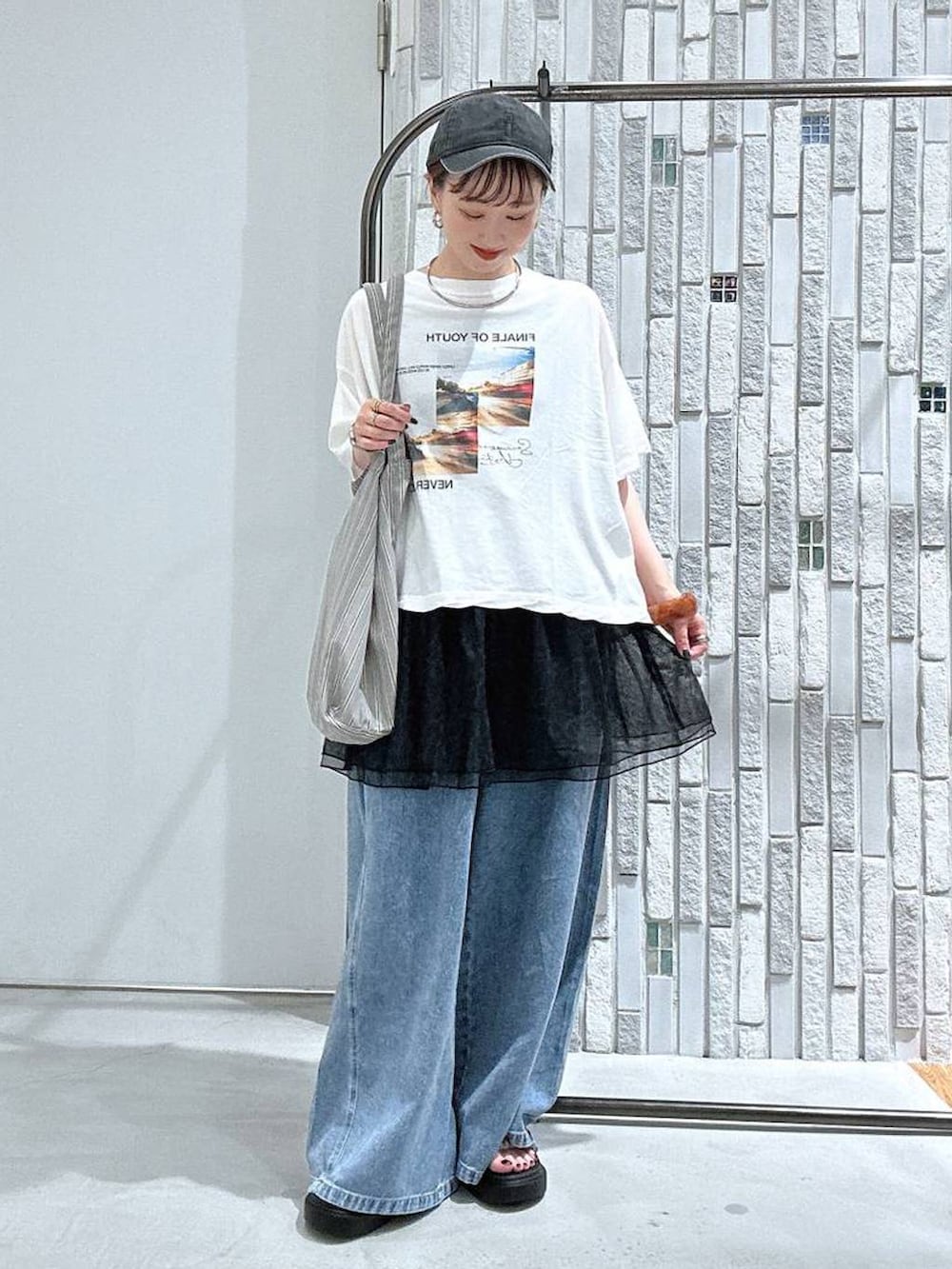 グレー系のトートバッグ、ホワイト系のTシャツ/カットソー、その他のサンダルを着用したレディースの夏コーディネートの3枚目の写真