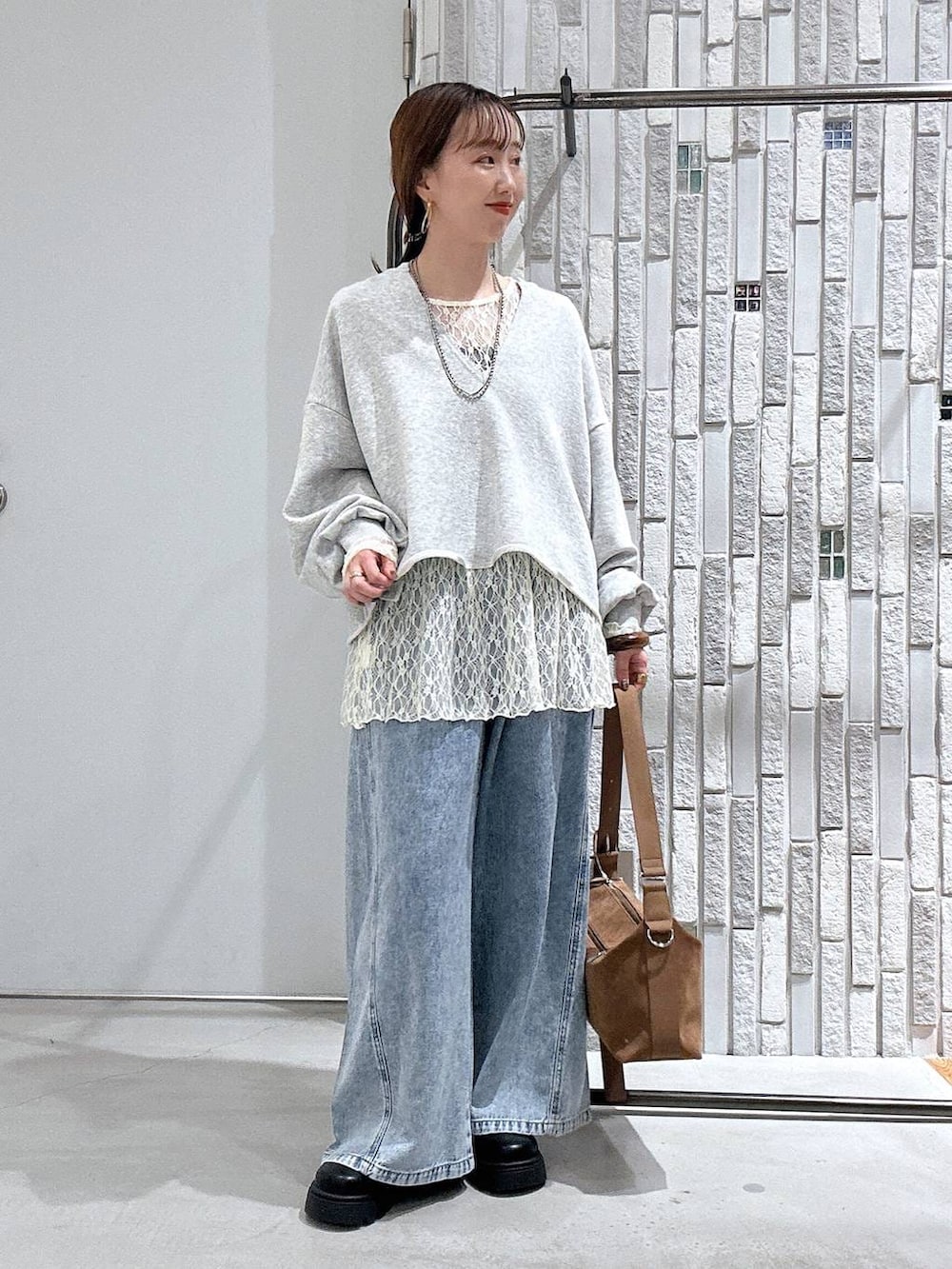 ブラウン系のショルダーバッグ、ブルー系のデニムパンツ、ブラック系のその他シューズを着用したレディースの春コーディネートの2枚目の写真