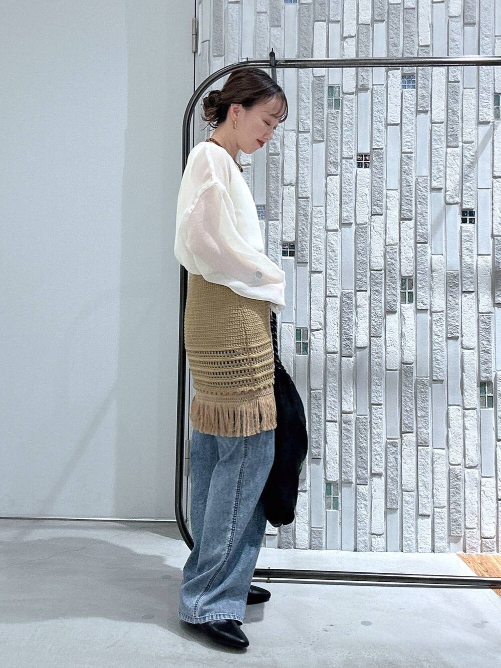 ブルー系のデニムパンツ、ブラック系のトートバッグ、ブラック系のパンプスを着用したレディースの春コーディネートの4枚目の写真