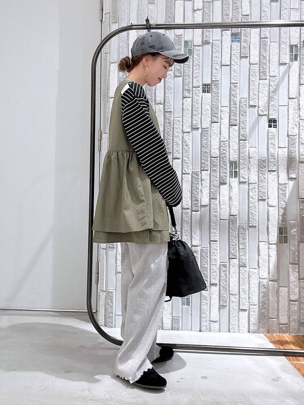 ブラック系のショルダーバッグ、ブラック系のTシャツ/カットソー、ブラック系のスニーカーを着用したレディースの冬コーディネートの2枚目の写真